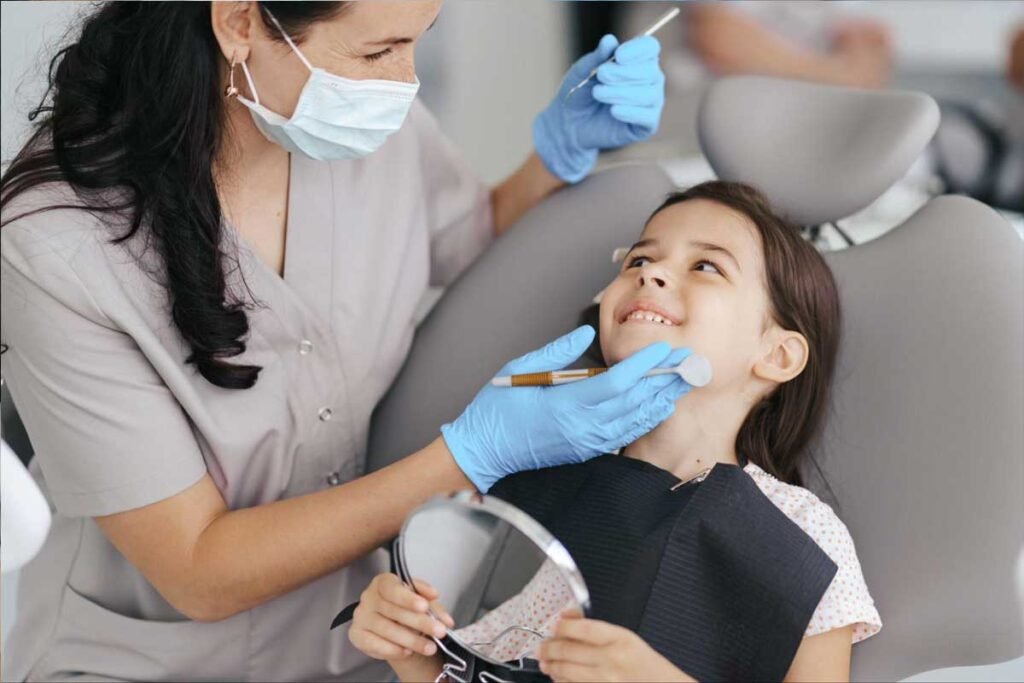 Female dentist gently examining a young girl’s mouth during a dental checkup.