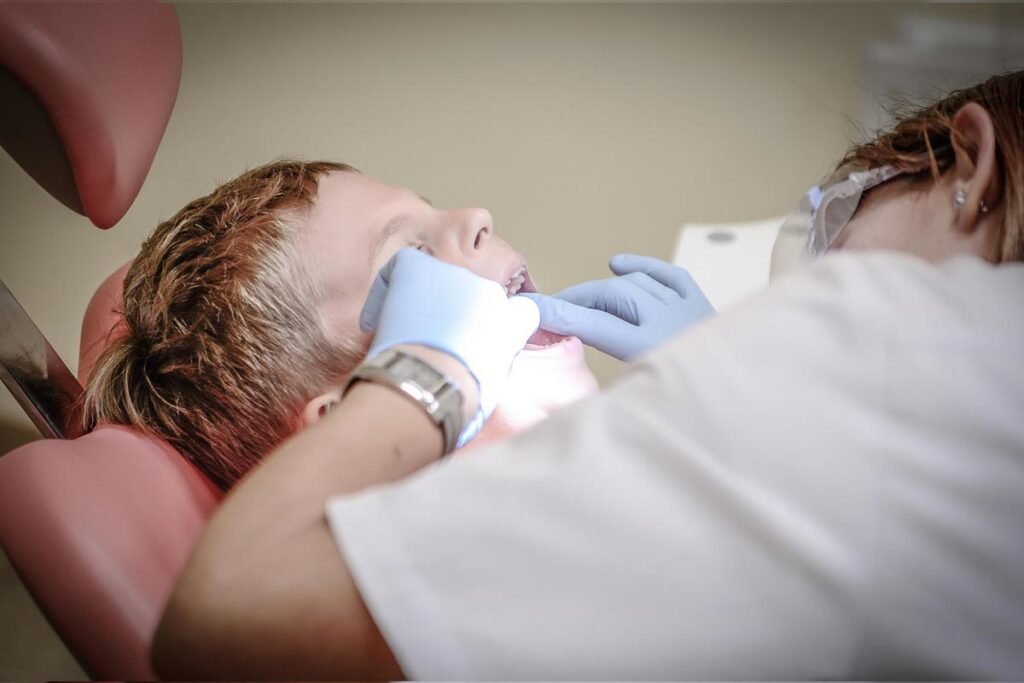 Female dentist examining a young boy’s mouth